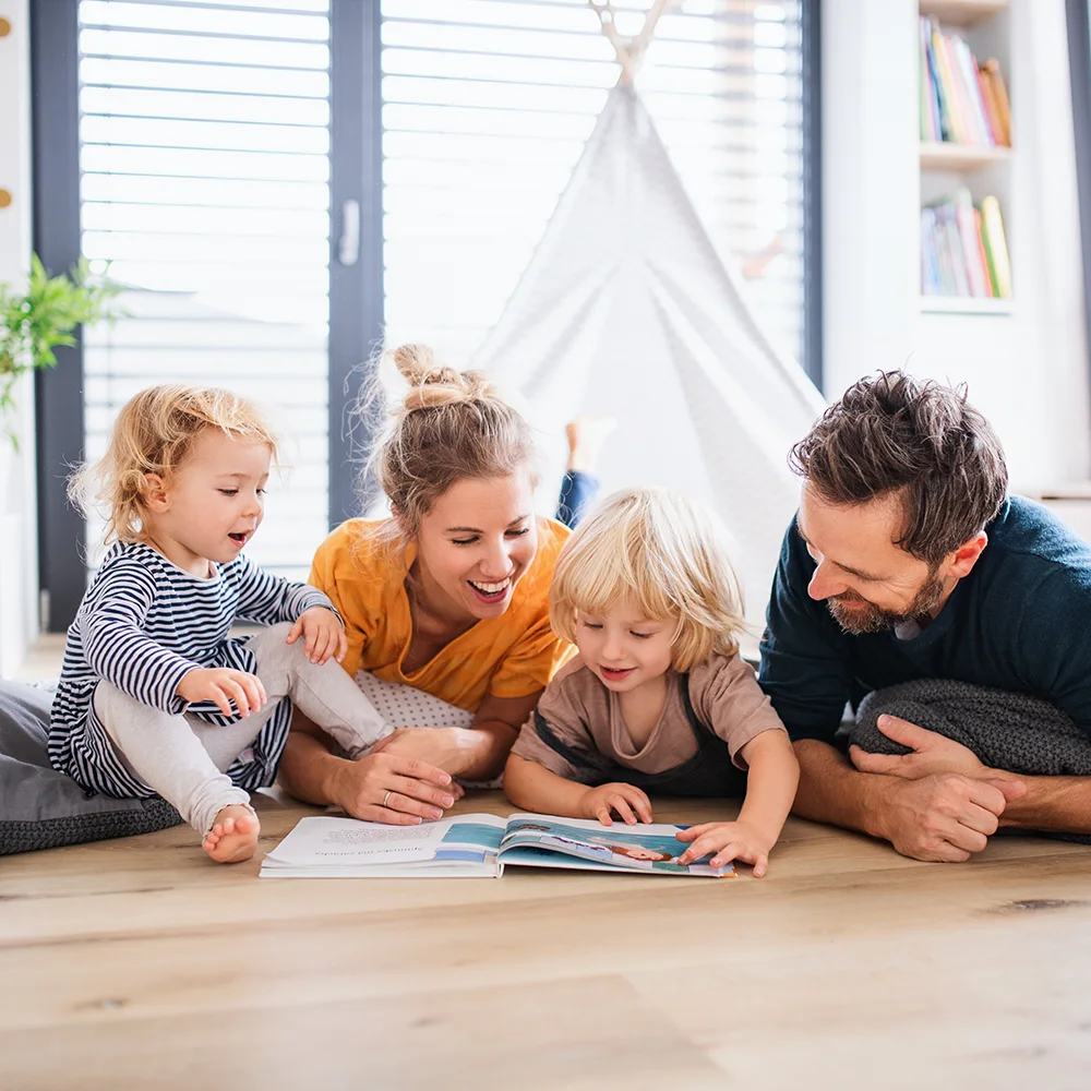 A family lays on the floor playing together