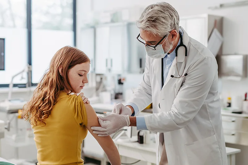 A teenage girl receives a vaccine