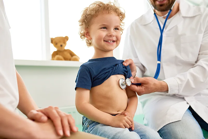 A toddler smiles while having a check up