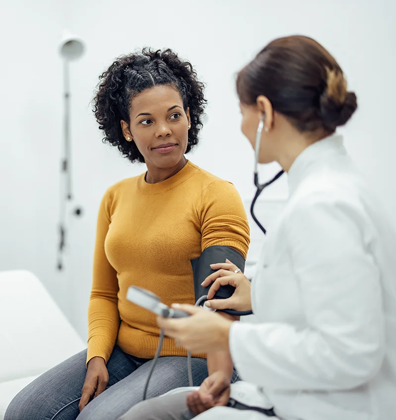 A woman has her blood pressure taken during a physical examination